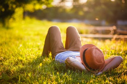 A relaxed student lying down on grass